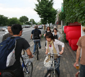 Crowded Bicycle Sidewalk Art opening purs into a busy sidewalk full of bicycles in Kyoto, Japan